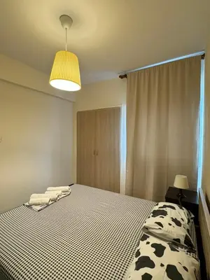 a bedroom with a bed with a black and white blanket at Magic Sea Apartments in Larnaka