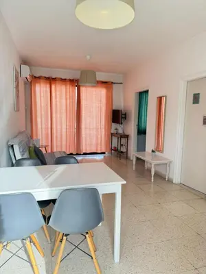 a living room with a white table and chairs at Magic Sea Apartments in Larnaka