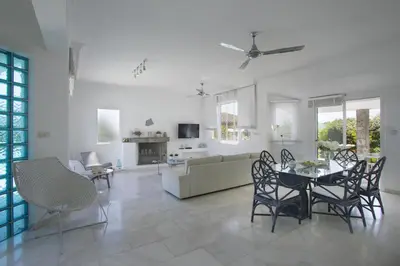 a white living room with a table and chairs at Protaras Villa Mazeri in Protaras