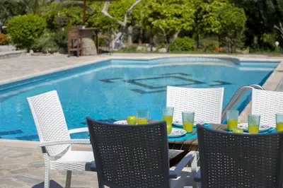 a table with drinks on it next to a swimming pool at Protaras Villa Mazeri in Protaras