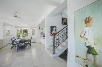 a living room with a staircase and a painting on the wall at Protaras Villa Mazeri in Protaras