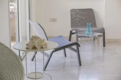 a room with two chairs and a table and a vase at Protaras Villa Mazeri in Protaras