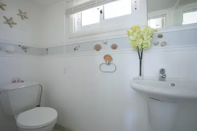 a white bathroom with a toilet and a sink at Protaras Villa Mazeri in Protaras