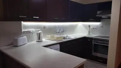 a kitchen with black cabinets and a white counter top at Kika Court 2 in Paralimni