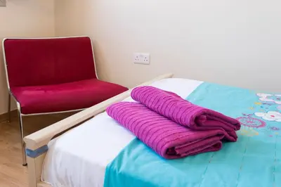 a bed with a red chair and a purple blanket at Amathousa Coastal Heights D202 in Limassol