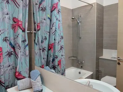a bathroom with a shower curtain with a toilet and a tub at Amathousa Coastal Heights D202 in Limassol