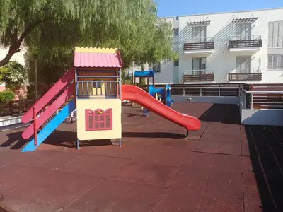 a playground with a slide in front of a building at Amathousa Coastal Heights D202 in Limassol