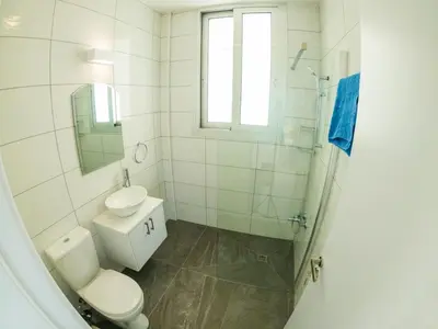 a white bathroom with a toilet and a sink at Imperial Jade Villas Gold Emerging Villas 2 in Protaras