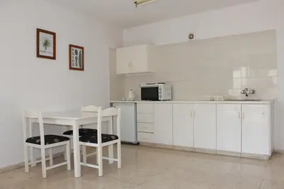 a kitchen with a table and chairs and a microwave at Florea Hotel Apartments in Ayia Napa