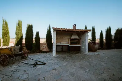 an outdoor pizza oven in a courtyard with a cart at Grand Mansion Countryhouse & Spa in Phrenaros