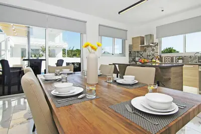 a dining room table with a vase of flowers on it at Villa Napa View in Ayia Napa