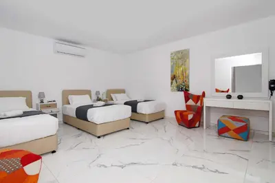 a bedroom with three beds and a marble floor at Villa Napa View in Ayia Napa
