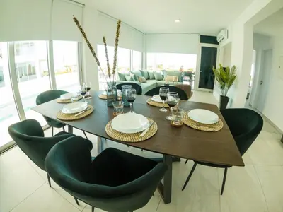 a dining room table with chairs and wine glasses at Imperial Jade Villas Gold Emerging Villas 1 in Protaras
