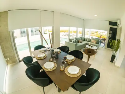 a dining table and chairs in a living room at Imperial Jade Villas Gold Emerging Villas 1 in Protaras