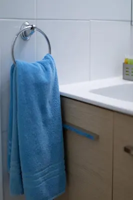 a blue towel hanging on a towel rack in a bathroom at Hotel Opera in Larnaka