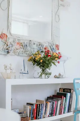 a shelf with a vase of flowers and books at Hotel Opera in Larnaka