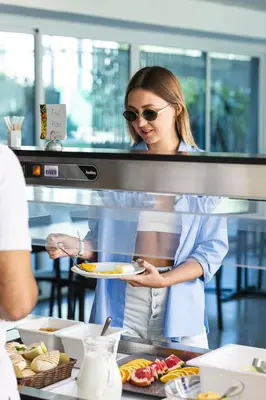 a woman is holding a plate of food at TSANotel in Limassol