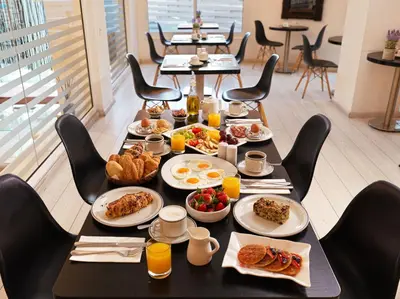 a table with breakfast food on it in a restaurant at TSANotel in Limassol
