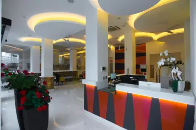 an office lobby with a colorful counter and flowers at TSANotel in Limassol