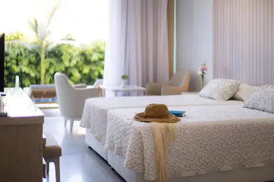 a bedroom with a bed with a hat on it at Tasia Maris Beach Hotel - Adults Only in Ayia Napa