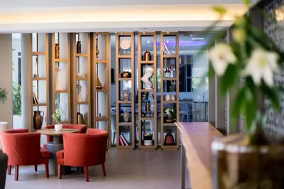 a room with a table and chairs and a wall of shelves at Tasia Maris Beach Hotel - Adults Only in Ayia Napa