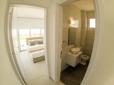 a bathroom with a sink and a toilet and a mirror at Imperial Jade Villas Gold Emerging Villas 3 in Protaras