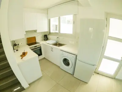 a white kitchen with a washing machine in it at Imperial Jade Villas Gold Emerging Villas 3 in Protaras