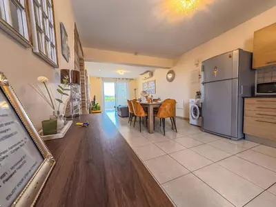 a kitchen and dining room with a table and a refrigerator at NISSI BEACH POOL VIEW APARTMENT FREE WIFI in Ayia Napa