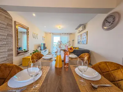 a dining room with a wooden table with wine glasses at NISSI BEACH POOL VIEW APARTMENT FREE WIFI in Ayia Napa