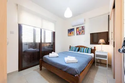 a bedroom with a bed and a desk and a window at Villa Alexandra by Ezoria Villas in Ayia Napa