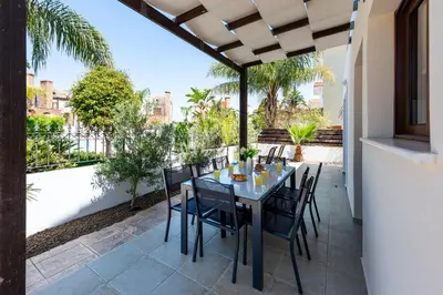 a patio with a table and chairs on a balcony at Villa Alexandra by Ezoria Villas in Ayia Napa