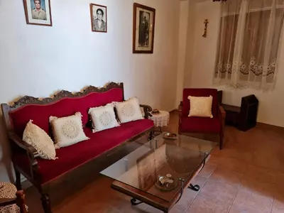 a living room with a red couch and two chairs at Kassandras place in Omodos village in Omodos