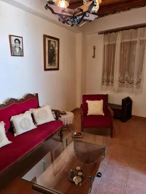 a living room with two red couches and a table at Kassandras place in Omodos village in Omodos