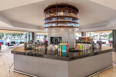 a bar in a restaurant with a large light at Olympic Lagoon Resort Ayia Napa in Ayia Napa