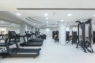 a gym with a row of treadmills and machines at Olympic Lagoon Resort Ayia Napa in Ayia Napa