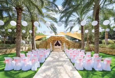 a set up for a wedding ceremony with palm trees at Olympic Lagoon Resort Ayia Napa in Ayia Napa