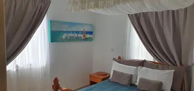 a bedroom with a bed and two windows at Casa Di Gio in Tersephanou