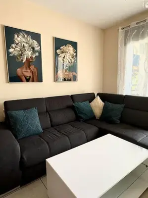 a living room with a black couch and a white table at NISSI BEACH Apt 7 BIG VERANDA AND FREE WIFI in Ayia Napa