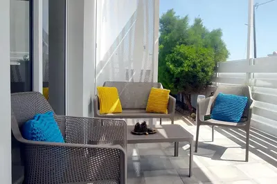 two chairs with colorful pillows sitting on a balcony at Nissini Shell, 3 bedroom villa with private pool at Nissi Beach in Ayia Napa