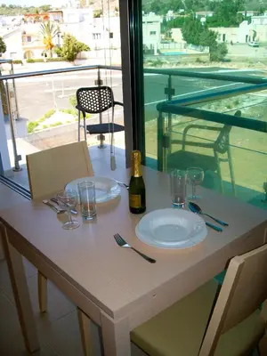 a table with a white plate and a bottle of wine at A209 Coralli Spa, Cyprus - Med View Studio in Protaras