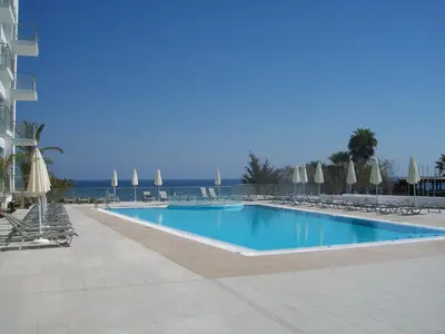 a large swimming pool with chairs and umbrellas at A209 Coralli Spa, Cyprus - Med View Studio in Protaras