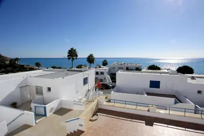 a view of white buildings with the ocean in the background at Pissouri Beach Apartments in Pissouri