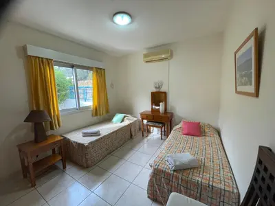 a hotel room with two beds and a window at Pissouri Beach Apartments in Pissouri