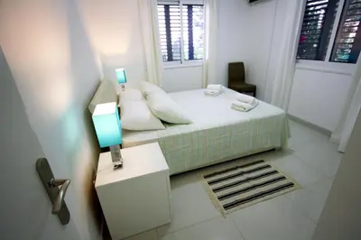 a small bedroom with a bed and a window at Pissouri Beach Apartments in Pissouri
