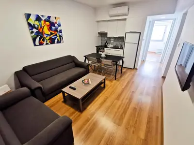 a living room with a couch and a table at Daze Off Central Apartment, 300m to the Finikoudes Beach in Larnaka