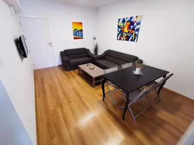 a living room with a couch and a table at Daze Off Central Apartment, 300m to the Finikoudes Beach in Larnaka