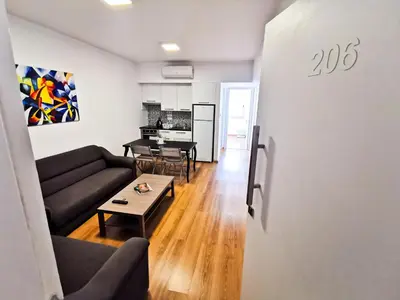 a living room with a couch and a table at Daze Off Central Apartment, 300m to the Finikoudes Beach in Larnaka
