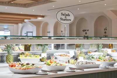 a buffet line with bowls of salads and strawberries at Atlantica Aeneas Resort in Ayia Napa