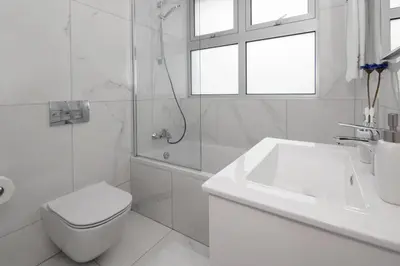 a white bathroom with a toilet and a sink at Villa Harmonia in Protaras
