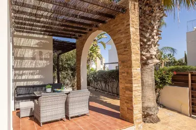 an outdoor patio with an arbor and a table and chairs at Villa Ionion 27 in Ayia Napa